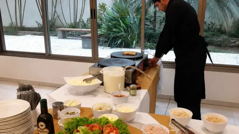 Profissional preparando crepe na estação durante evento