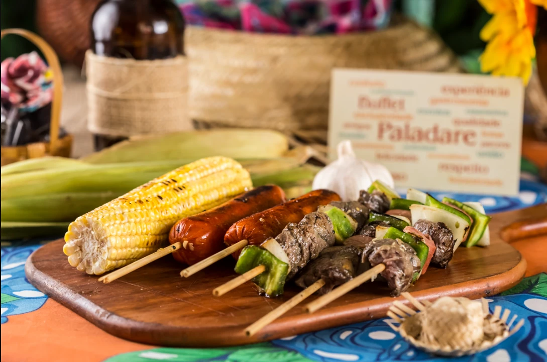 Espetinhos de carne, linguiça e milho verde do buffet de festa junina