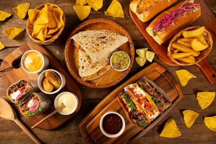 Mesa de comida mexicana com nachos, guacamole, quesadilla, tacos e burritos do Buffet Paladare