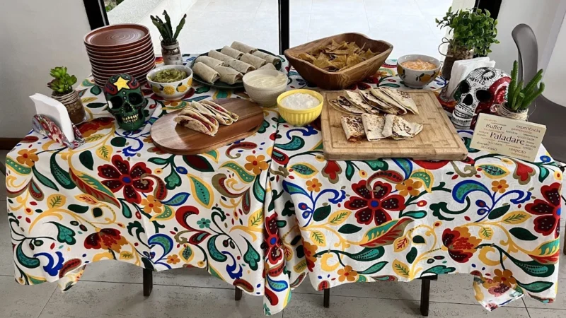 Mesa de entrada do buffet mexicano montada em evento, com nachos, quesadillas, burritos e molhos